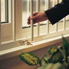 a person is holding a candle in front of a window with bars on the windowsill