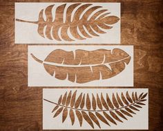 three cut outs of leaves on a wooden surface