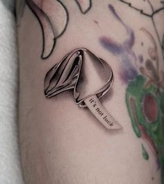 a close up of a person's leg with a tattoo on it and a ring