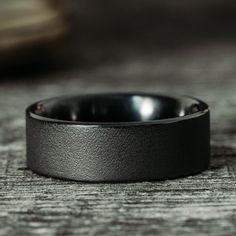 a black ring sitting on top of a wooden table