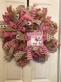 a pink and brown mesh wreath with a dog on it's front door hanger