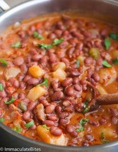 a pot filled with beans and vegetables on top of a stove