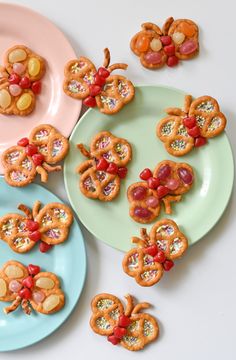 three plates with cookies decorated like bugs on them and candy in the shape of flowers