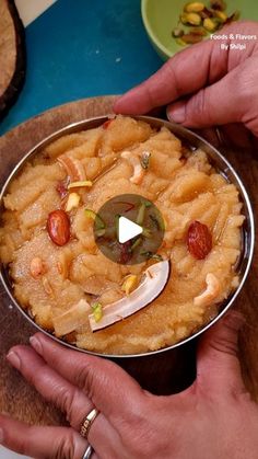 two hands holding a metal pan filled with food