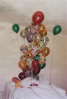 a bunch of balloons that are in the shape of basketballs with faces on them