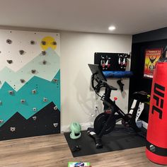 an indoor gym with climbing wall and exercise equipment in the corner, including a stationary bike