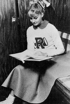 a woman sitting in a chair reading a book