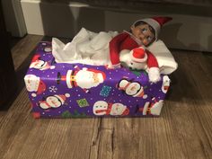 an elf is sitting on top of a wrapped present