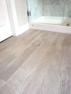 an image of a bathroom with wood flooring on the walls and in the bathtub