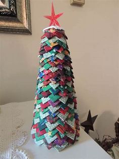 a small christmas tree made out of old magazines and other items sitting on a table