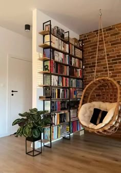 a hanging chair in front of a book shelf filled with books