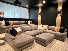 a large sectional couch sitting in the middle of a living room with pillows on it