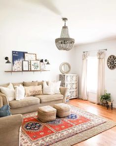 a living room filled with furniture and a chandelier hanging above the couches