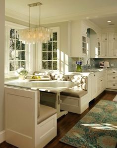 a kitchen with white cabinets and an island in front of the window that is open