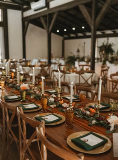 a long table set with place settings and candles