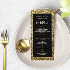 a white plate topped with a menu next to a gold fork and knife on top of a table