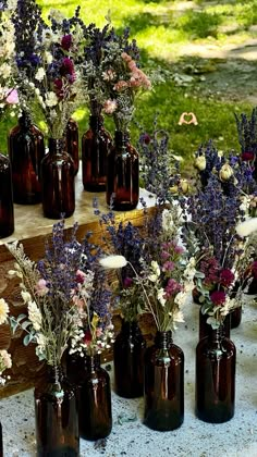 several brown vases filled with purple and white flowers