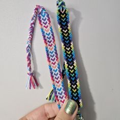 two colorful bracelets being held by a hand