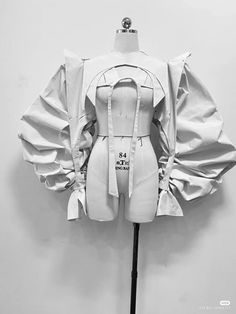 a mannequin is dressed in white with ruffled sleeves