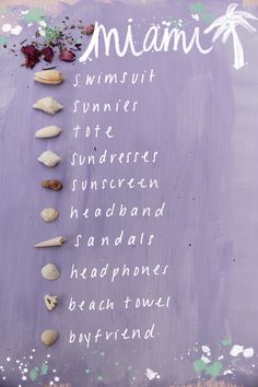 there is a sign with different types of seashells written in white on it