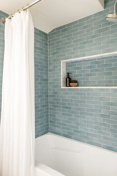 a white bath tub sitting next to a shower curtain