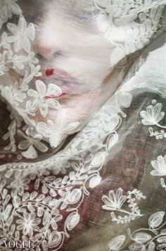 a woman wearing a veil with white lace on it