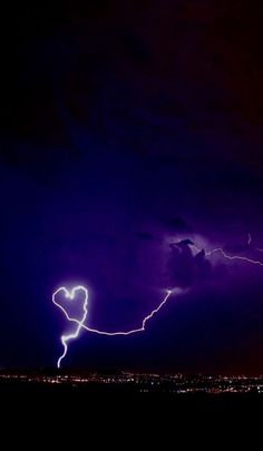 lightning striking over the city at night time