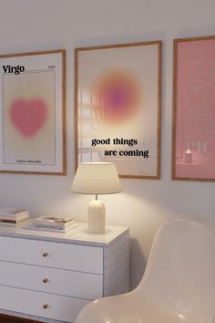 a white dresser topped with a lamp next to two framed pictures