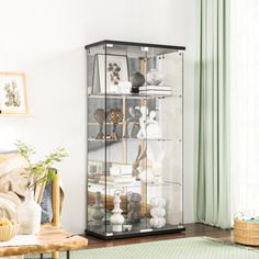 a living room filled with furniture and a glass case on top of a wooden table