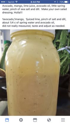 a yellow jar filled with liquid sitting on top of a table next to a potted plant