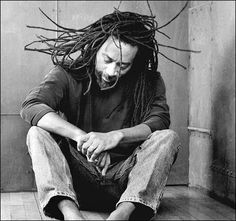 a man with dreadlocks sitting on the floor