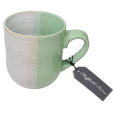 a green and white coffee cup with a tag