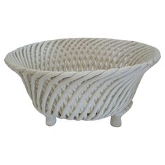 a white wicker bowl sitting on top of a wooden stand