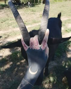 a person holding up their hand with an animal on it's face in front of them