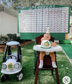 a baby sitting in a high chair next to a golf score board