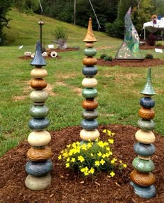 a group of rocks stacked on top of each other in a flower bed with yellow flowers