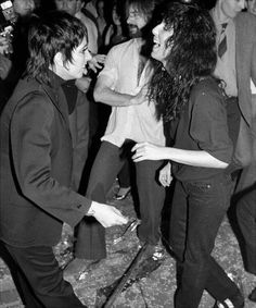 black and white photograph of two people dancing in front of a crowd at an event