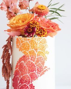 a vase filled with lots of flowers on top of a table