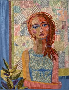 a woman with red hair and blue eyes is depicted in this handmade quilted wall hanging