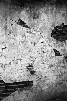 a black and white photo of an old wall with cracks in the paint on it