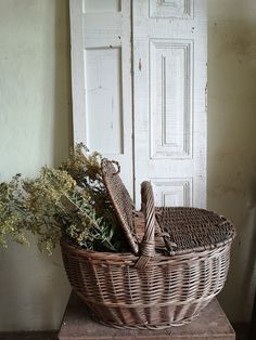 a wicker basket sitting on top of a wooden table next to a white door