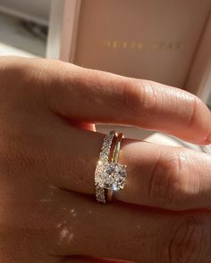 a woman's hand holding a diamond ring