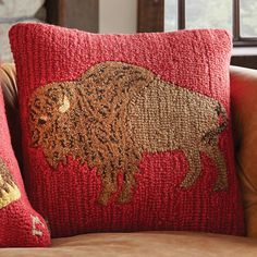 two red pillows sitting on top of a brown couch