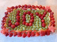 a platter filled with grapes, strawberries and watermelon