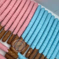 there are many different types of donuts in the display case, including one with pink and blue icing