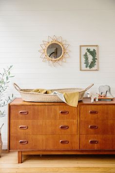 a wooden dresser with a basket on top of it