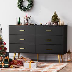 a christmas tree is next to a dresser with presents on it