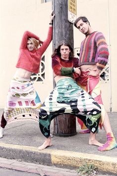 three people posing for a photo in front of a pole