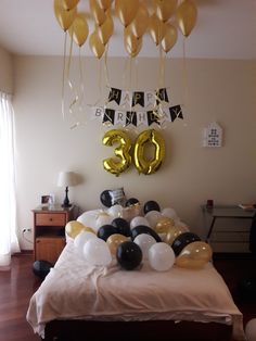 balloons and streamers are on the bed in this room with an 30th birthday decoration