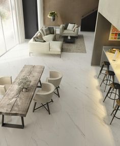 a living room filled with furniture next to a kitchen and dining table in front of a window